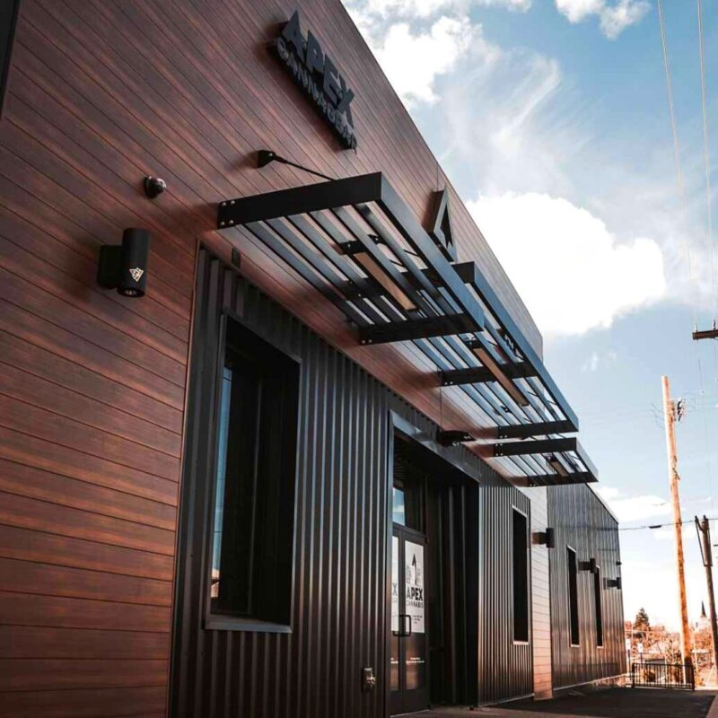 APEX Commercial Louvered Architectural Sunshade System The image shows a commercial building facade with Vestis louvered architectural sunshade systems mounted above the windows and entry area.