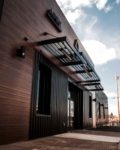 wood storefront retail with black powder coated sunshades