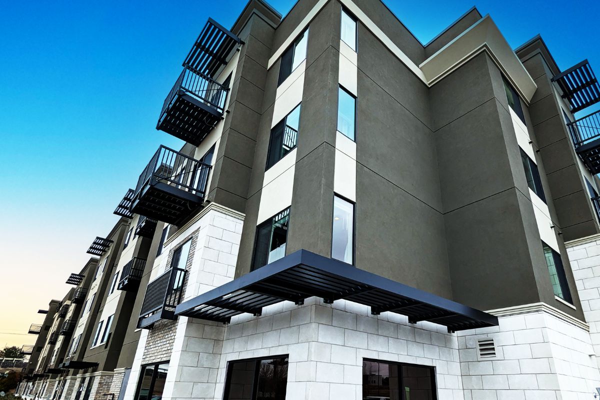 Louvered Sunshades and bolt-on balconies attached to a multistory apartment building with a bright blue sky