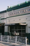 The image shows Iron Horse Bar & Grill with a black aluminum awning from Vestis extending over the storefront, covering outdoor seating and the main entrance.