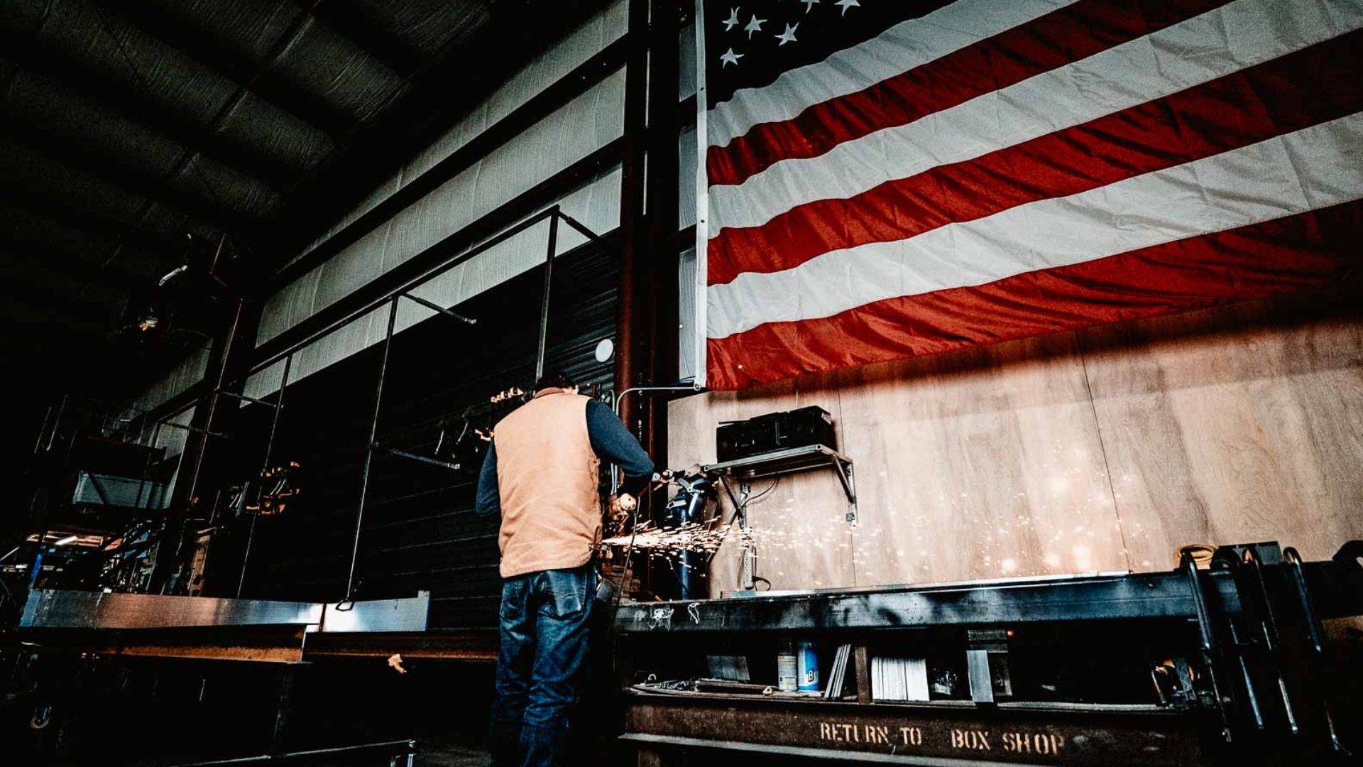 RIcky Welding vestis veteran welding a canopy with usa flag in the background