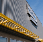 The image shows Vestis aluminum louvered sunshades and brise soleil installed on a modern building façade for solar shading.