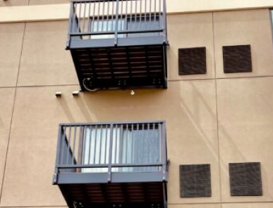 two aluminum bolt-on balconies attached to a multifamily hotel