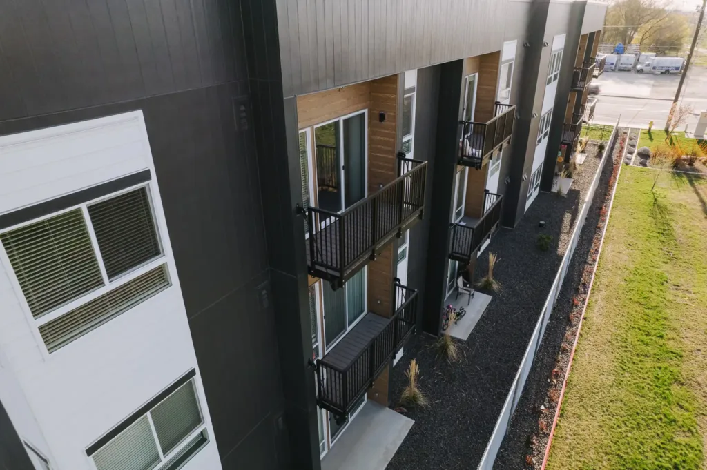 Urban Pines Aluminum Bolt-On Balconies The image shows Vestis Architectural Products featuring aluminum bolt-on balcony systems installed on Urban Pines Apartments, with black railing Architectural Systems along the exterior.