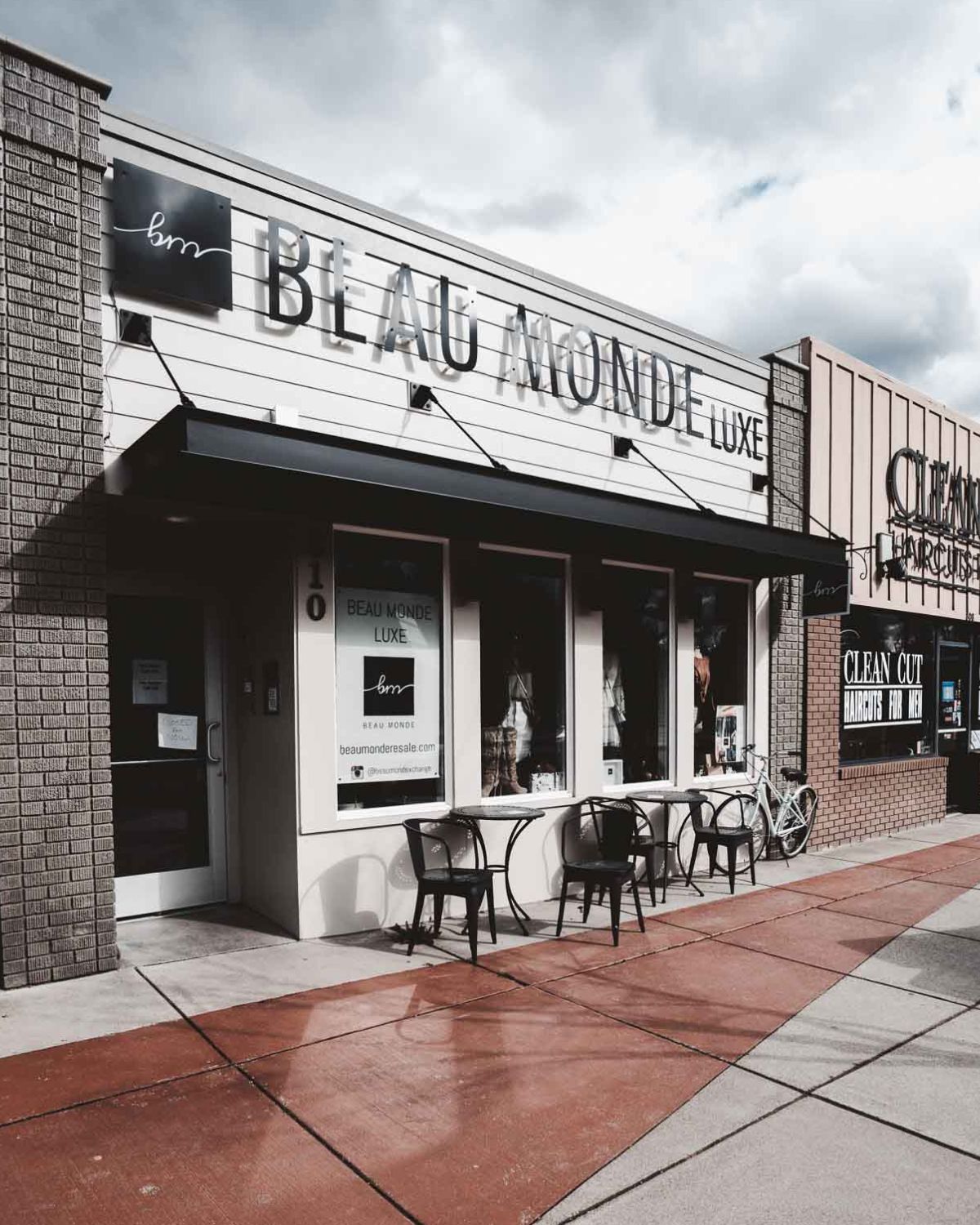 black powder coated aluminum canopy installed on a retail store with a walking path below